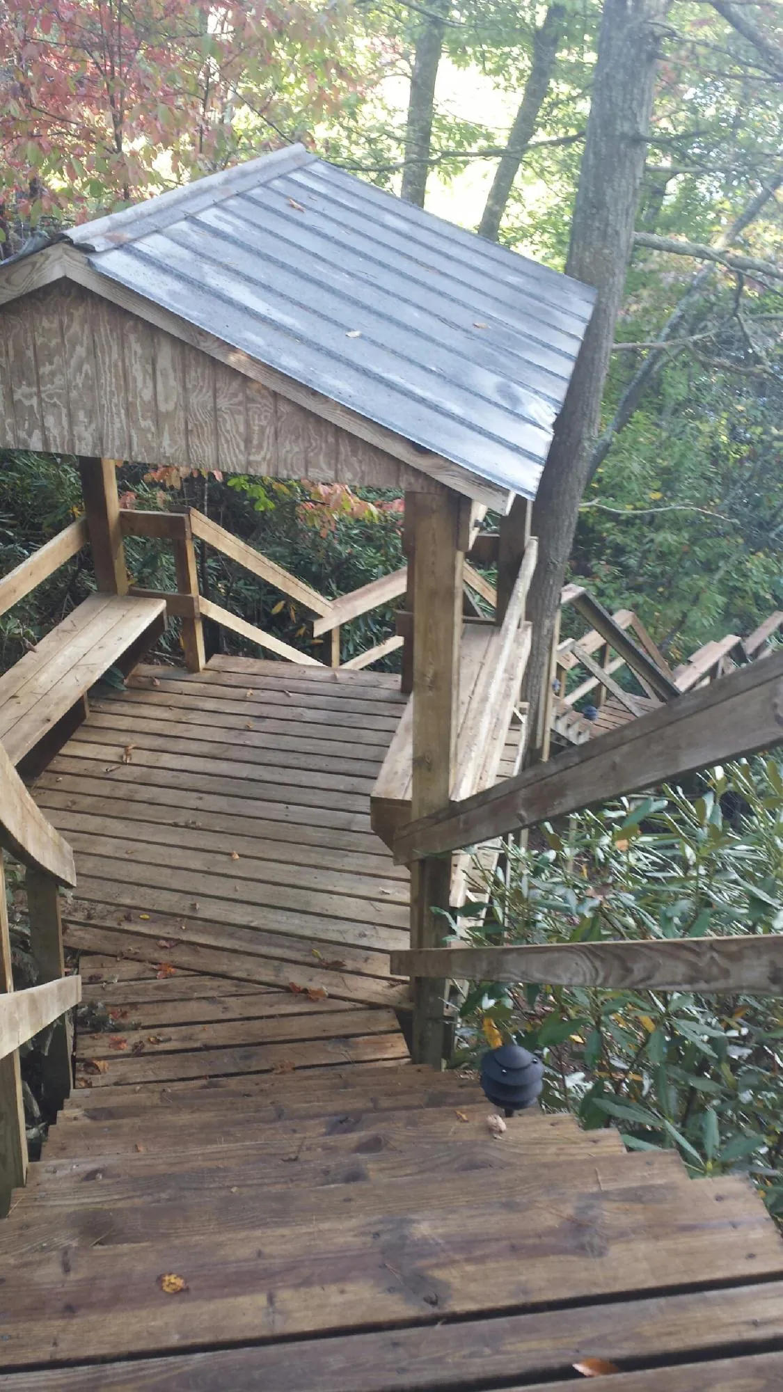 Metal roofed shelter over wooden steps on a wooded walkway — Skylight Repair & Installation work by our crew in Elkhart