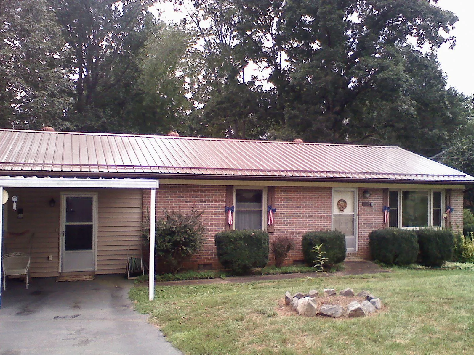 Bronze metal roof and carport on a brick ranch home — Roof Repair work by our crew in Elkhart